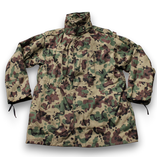 A Romanian M1994 'Fleck' winter jacket with camouflage pattern in various shades of green and a hood.